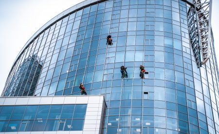 Several workers washing windows in the office building